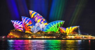 Colourful image projected on the side of the Sydney Opera house during an economical vacation in Sydney.