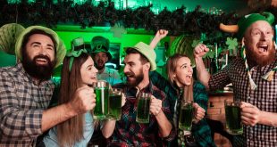 Young people celebrating St. Patrick's Day at a bar with green drinks and accessories.