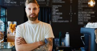 Male barista standing at a trendy coffee shop that serves some of the best coffee in LA.