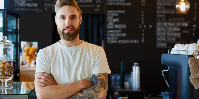 Male barista standing at a trendy coffee shop that serves some of the best coffee in LA.