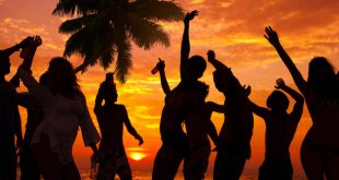 Silhouettes of people partying on a Caribbean beach with Stripe, the best Jamaican beer.