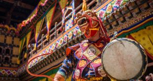 Buddhist monk dancing with a dragon mask at Paro Tsechu festival in Bhutan, a great ocassion for trying typical Bhutanese dishes.