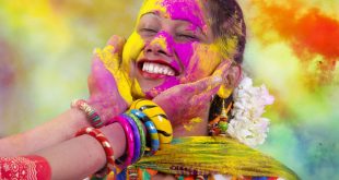 Fun, Food and Festivals in India. Portrait of a young Indian woman celebrating the Holi color festival.