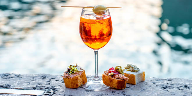 Spritz Aperol drink with traditional cicchetti snacks, some of the best foods to eat in Venice.