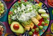 Buy international foods. Mexican green enchiladas with guacamole and sauces on colorful table.